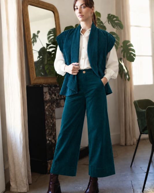 Veste kimono en velours côtelé bio canard portée ouverte sur une chemise ivoire avec le pantalon Marinette canard, une main dans la poche.