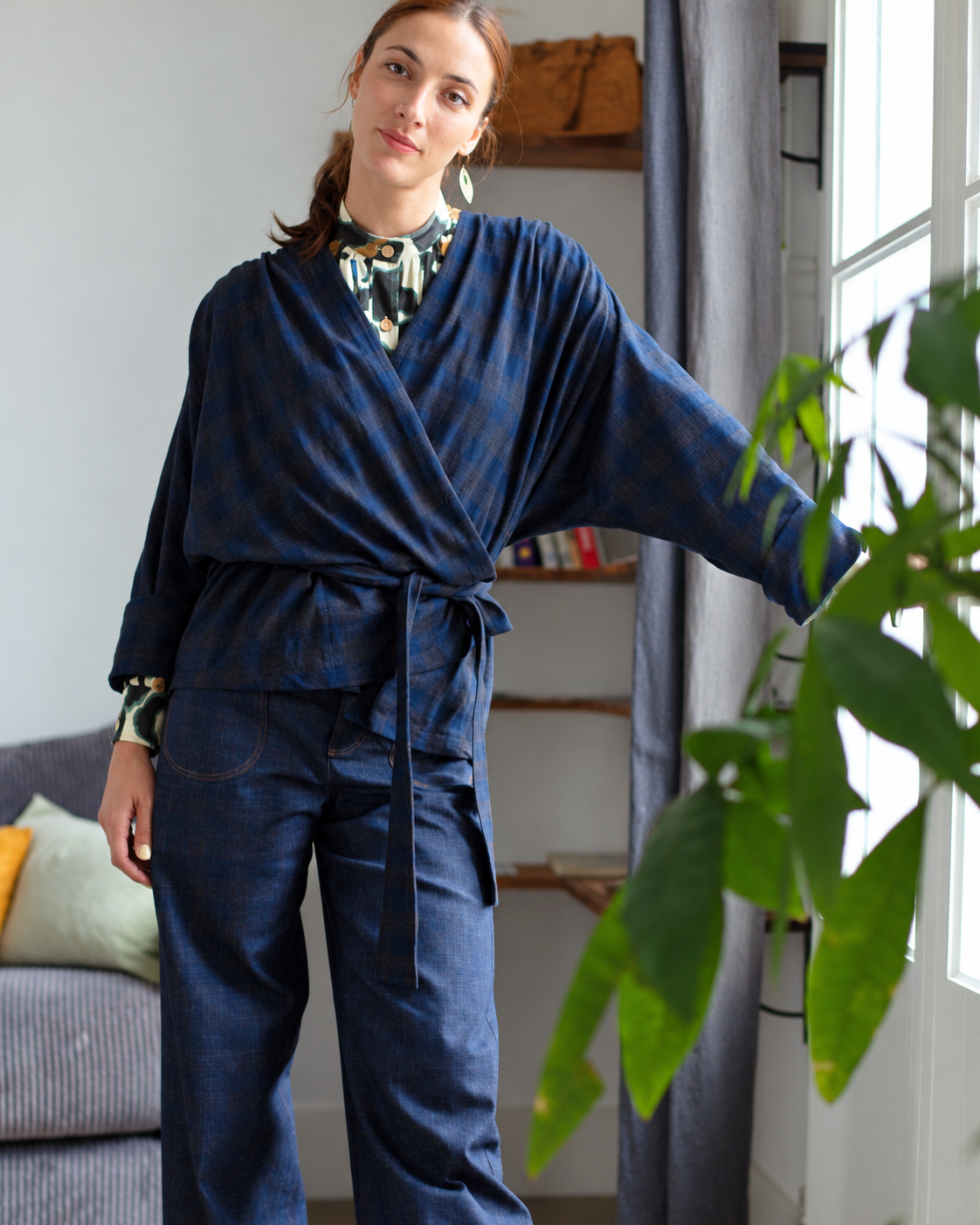 Veste Louison Carogarden Atelier Tiket à carreaux bleu marine, portée en cache-cœur et nouée à la taille.